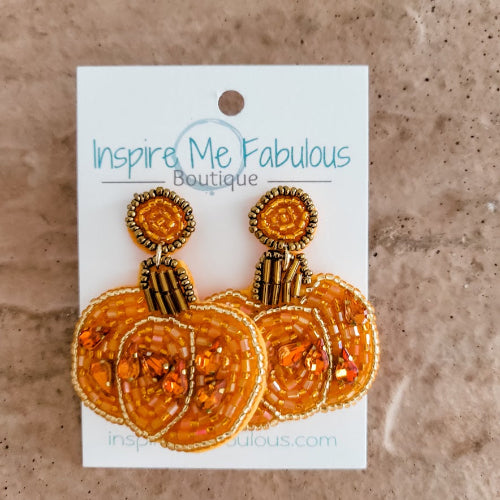 Pumpkin-shaped earrings on a card with 'Inspire Me Fabulous Boutique' branding.
